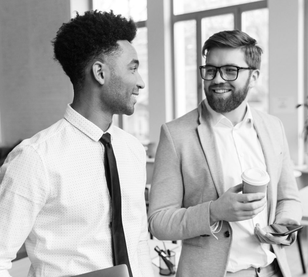 Image of happy businessmen colleagues talking with each other drinking coffee.